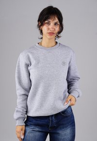 Hellgraues Sweatshirt mit Rundhalsausschnitt und gerippten Bündchen. Verfügt über ein dezentes Logo auf der Brust; der Stoff wirkt weich und texturiert.