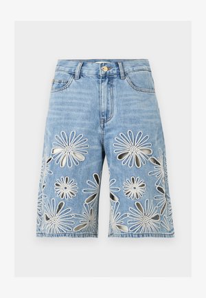 Lyseblå denimshorts med frontknap, bæltestropper og store hvide broderede blomsterudskæringer på begge ben.