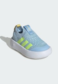 Blue knit slip-on sneaker with yellow and green accents, featuring a rounded white sole, elastic collar, and textured upper pattern.