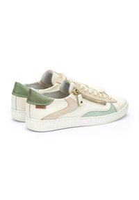 Baskets en cuir beige avec des accents verts, des panneaux texturés et une fermeture éclair sur le côté. Elles présentent une semelle blanche mouchetée et un doublure gris doux.