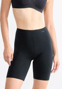 Schwarze Radshorts aus glattem, dehnbarem Stoff. Sie verfügen über einen hohen Taillenbund und eine enge Passform, die bis zur Mitte des Oberschenkels reicht. Dezentes Logo sichtbar.