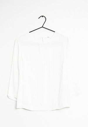 Biała, długa bluzka z długim rękawem, okrągłym dekoltem, wykonana z gładkiego materiału. Posiada zapięcie na guziki z tyłu i luźny krój.