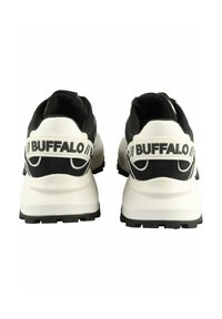 Paire de baskets de la marque Buffalo, noires et blanches, vues de dos avec des semelles blanches épaisses et une semelle noire.