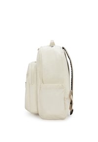Mochila beige con tejido texturizado, dos compartimentos con cremallera y un bolsillo lateral. Presenta correas ajustables y un asa en la parte superior.