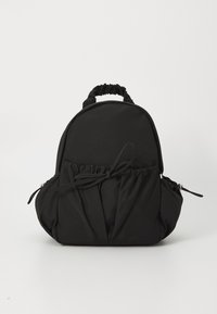 Black fabric backpack with a rounded shape, gathered detailing at the bottom, elasticized top handle, and side zippers for closure.