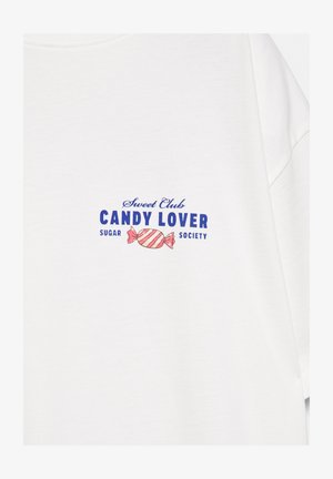 T-shirt blanc avec le texte bleu « Sweet Club CANDY LOVER Sugar Society » et un graphique de bonbon rayé rose centré sur la poitrine.