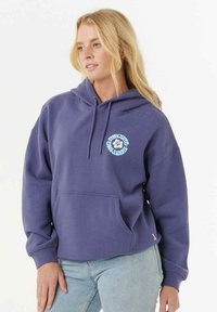 Lilla hoodie lavet af blødt stof, med en kengurulomme og en cirkulær grafisk tryk på brystet. Justerbar hætte med snøre.