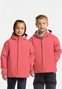 Due bambini indossano giacche impermeabili color corallo acceso con cappucci. Le giacche presentano dettagli riflettenti e una chiusura frontale con cerniera.