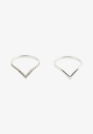 Two silver V-shaped rings on a white background, one plain and one adorned with small clear gemstones along the top edges.