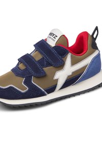 Scarpa atletica blu marina e oliva con accenti bianchi, materiale in suede e nylon, cinturini in velcro e suola esterna in gomma nera robusta.