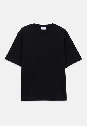 Camiseta oversized de manga corta en negro con escote redondo y etiqueta de la marca Filippa K visible en el interior del cuello.
