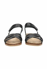 Schwarze Ledersandalen mit Kreuzriemen, verstellbarem Knöchelriemen und einer natürlich strukturierten Fußbett. Flache Sohlen in einem hellen Tan-Farbton.