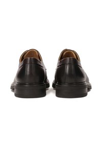 Scarpe in pelle nera con una texture liscia, bordi arrotondati e tacco di supporto. Presentano una fodera interna imbottita di colore beige.