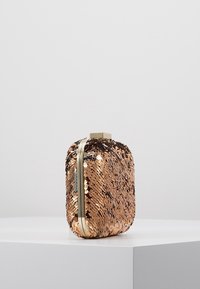 Clutch i roséguld med paljetter, rektangulär form, detaljer i guld och en slät, skimrande yta. Stängning med ett lås på toppen.