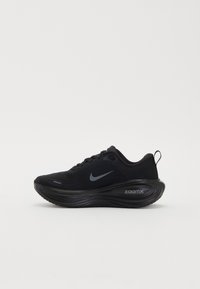 Chaussure de running noire Nike avec semelle épaisse amortie ZoomX et logo Swoosh réfléchissant sur le côté, montrée en profil gauche sur fond blanc.