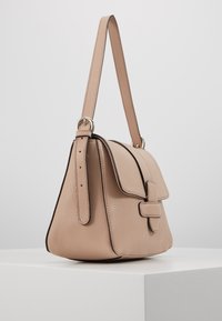Béžová kožená kabelka se strukturovaným designem, zavíráním na klopu a nastavitelným popruhem; disponuje texturovaným povrchem a jemnými švovými akcenty.