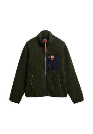 Chaqueta de forro polar verde con cuello alto, cremallera frontal, bolsillo en el pecho azul marino, dos bolsillos laterales con cremallera y detalle de tira de cuero en la cremallera.