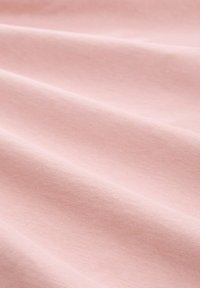 Tela de color rosa claro con una textura suave y lisa, que presenta arrugas sutiles y una apariencia uniforme, ideal para una variedad de aplicaciones textiles.