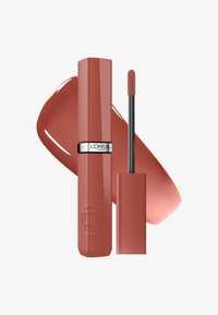 Rouge à lèvres liquide mat terracotta avec applicateur, à côté d'un échantillon, marqué L'Oréal Paris sur fond blanc.