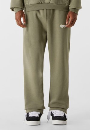 Olive green sweatpants made of soft fabric, featuring a relaxed fit and ribbed waistband. Notable logo detail on the left thigh.