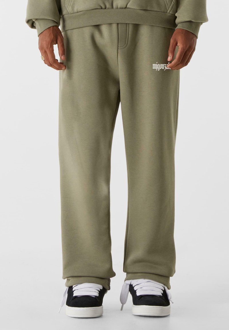 Olivengrønne sweatpants lavet af blødt stof, med en afslappet pasform og ribbet talje. Bemærkelsesværdig logo-detalle på venstre lår.