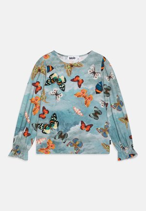 Chemise à manches longues avec un fond de ciel bleu et des motifs colorés de papillons en nuances d'orange, de vert, de blanc et de bleu.