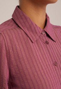 Camicia button-up a righe viola con colletto; tessuto testurizzato, dotata di bottoni coordinati e una leggera lucentezza.