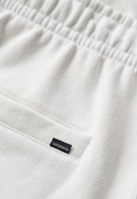 Superdry & Co EMBOSSED - Pantalon de survêtement - new chalk white