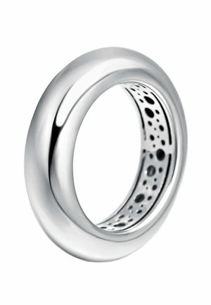 Anillo de plata con un exterior liso y pulido. El interior presenta un patrón perforado, que añade textura y contraste visual.