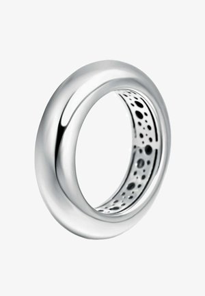 Anillo de plata con un exterior liso y pulido. El interior presenta un patrón perforado, que añade textura y contraste visual.