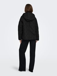 Black quilted jacket with a hood, featuring a diamond pattern. Paired with dark blue wide-leg pants.