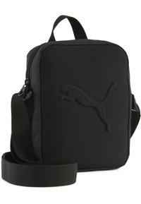 Sac bandoulière noir en tissu avec fermeture éclair, de forme plate, sangle ajustable et logo Puma texturé embossé sur le devant.