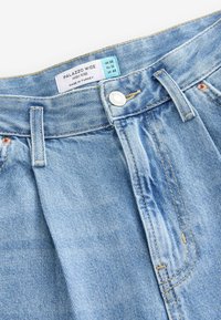 Jean palazzo large taille haute bleu clair avec bouton métallique et passants de ceinture, étiqueté UK 8R, EU 36, US 4R, fabriqué en Turquie.