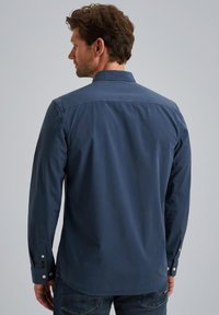 Navyblaues Langarmhemd mit Button-Down-Kragen, geradem Saum und Manschettendetails; hergestellt aus glattem Stoff mit lockerer Passform.