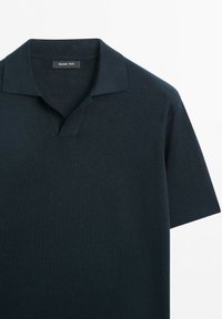 Polo a maniche corte blu navy scuro con colletto aperto, realizzato in tessuto fine a maglia, con etichetta Massimo Dutti all'interno del collo.