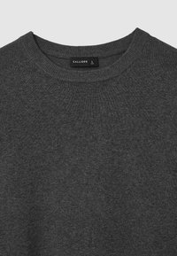 Grauer Strickpullover mit Rundhalsausschnitt, der eine subtile Textur aufweist. Das Etikett lautet "CALLIOPE", Größe L. Es sind keine Muster oder Akzente vorhanden.