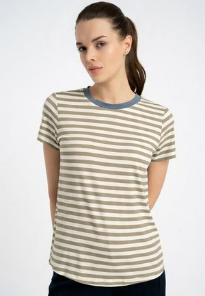 Młoda kobieta z ciemnym kucykiem, ubrana w beżowo-biały, poziomo w paski t-shirt z krótkim rękawem i niebieskim okrągłym kołnierzem.