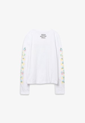 Chemise blanche à manches longues avec texte "vans off the wall" sur le haut du dos et motifs floraux bleus avec des carrés pastel le long des deux manches.