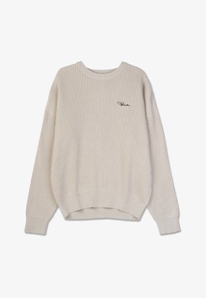 Beež ribatud kudum, millel on ümar kaelus ja langenud õlad. Ees on broderi logoga. Pehme tekstuur, lõdvestunud istuvus.