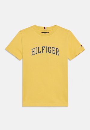 T-shirt in cotone giallo con logo "HILFIGER" blu navy sul petto, collo rotondo e maniche corte con piccolo accento logo su una manica.