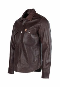 Barna bőrkabát galléros nyakkivágással, két mellzsebbel és patentgombos záródással; texturált felülettel és ívelt szegéllyel rendelkezik.