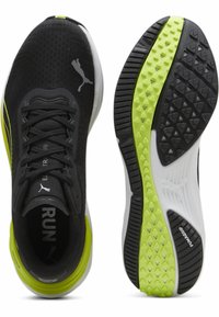 Zapatillas de running negras con parte superior de malla, presentan un acento en verde lima, suela acolchada y suela de goma texturizada para mayor tracción.