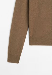 Brązowy dzianinowy sweter ze wskazaniem na rękawy i dolny ściągacz na białym tle, ukazujący delikatne szczegóły prążkowanych mankietów i pasa.