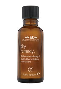 Aceite hidratante diario Aveda dry remedy��™ en un frasco de vidrio ámbar de 30 ml. Tapa negra estriada; texto blanco en la parte frontal con detalles del producto.