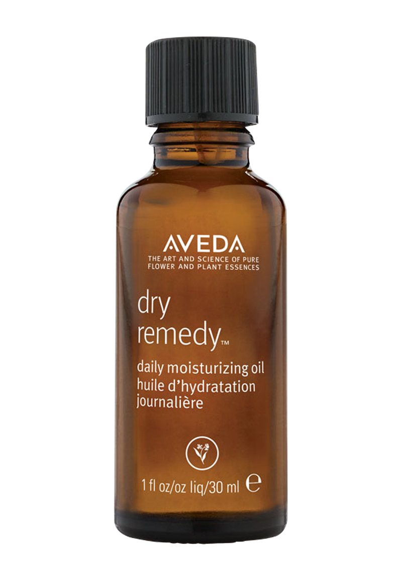 Aceite hidratante diario Aveda dry remedy™ en un frasco de vidrio ámbar de 30 ml. Tapa negra estriada; texto blanco en la parte frontal con detalles del producto.