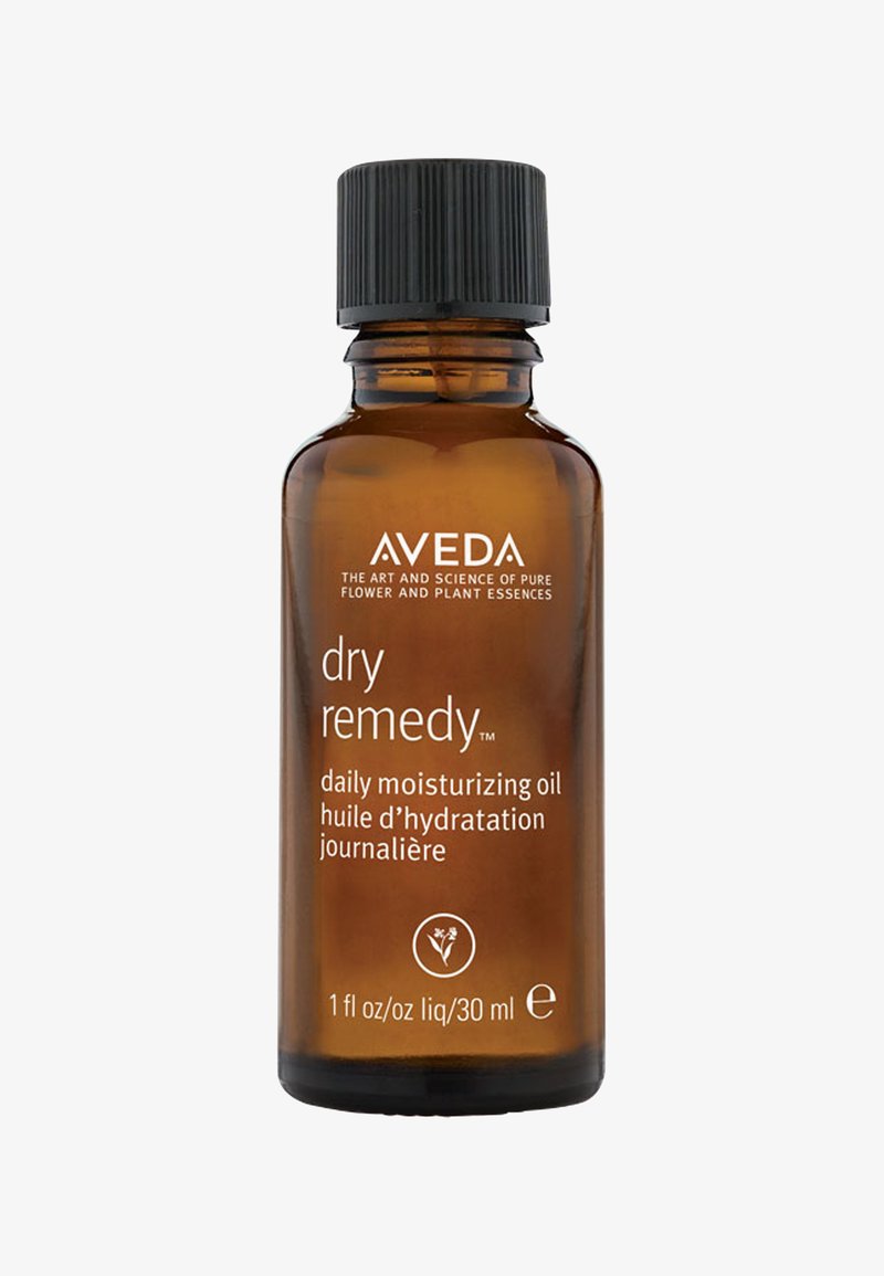 Aceite hidratante diario Aveda dry remedy™ en un frasco de vidrio ámbar de 30 ml. Tapa negra estriada; texto blanco en la parte frontal con detalles del producto.