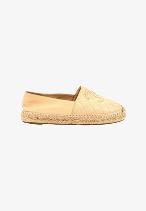 Espadrille en cuir beige avec coutures matelassées, semelle en corde tressée, et logo embossé sur la partie avant supérieure.