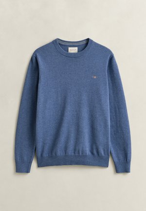 Blauwe trui met lange mouwen en ronde hals, geribbelde boorden en zoom, klein geborduurd schildlogo op de linkerborst, plat uitgespreid op een neutrale achtergrond.