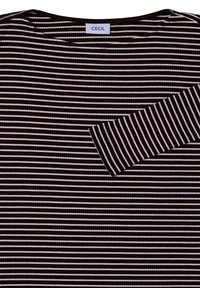 Viirin pitkähihaine paita tumma ruskea ja valkoinen, jossa on ribbikuvio ja rintatasku. Tagi lukee "CECIL."