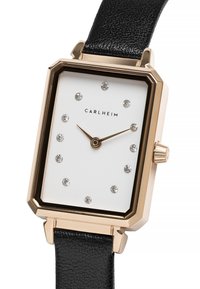 Reloj de pulsera rectangular con caja de oro rosa, esfera blanca y correa de cuero negra. Presenta marcadores de cristal y manecillas doradas. Corona en el lateral.